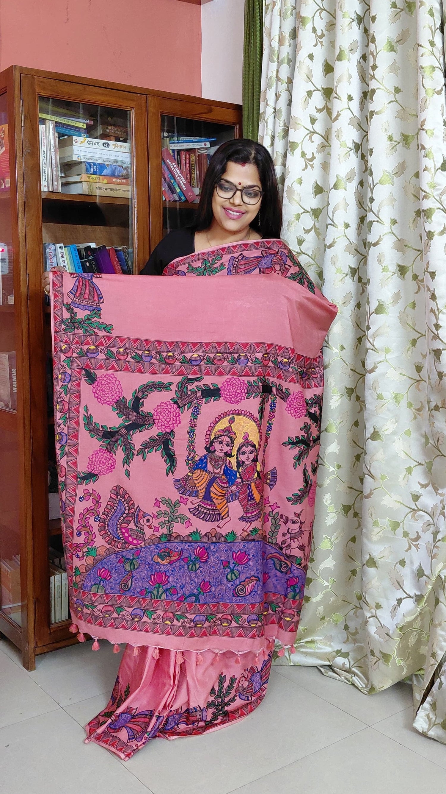 Woman wearing blush pink Katan silk Madhubani saree with Radha Krishna pallu artwork