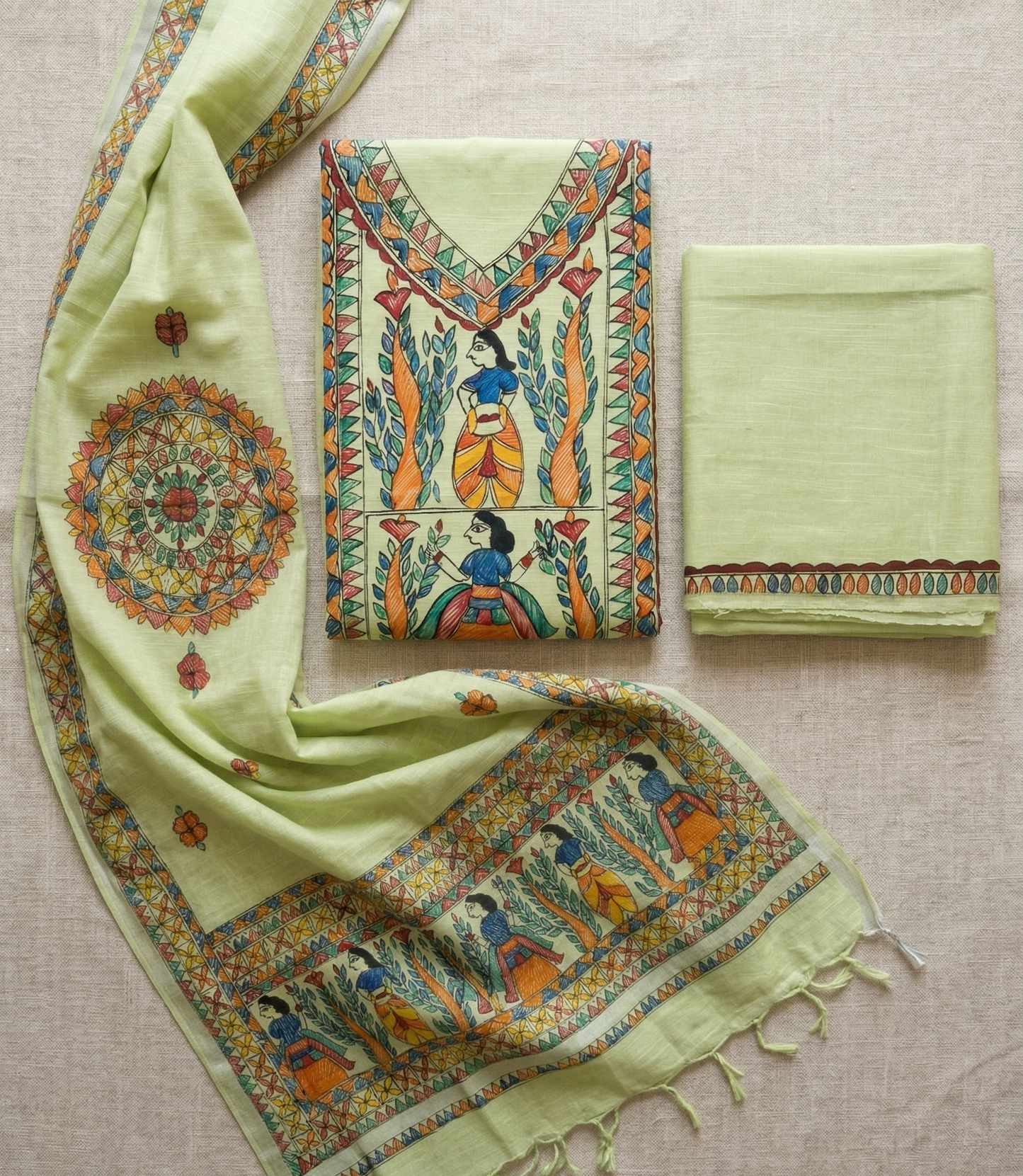 Unstitched green Madhubani suit set flat lay showing kurta panel, dupatta with mandala motif and bottom fabric