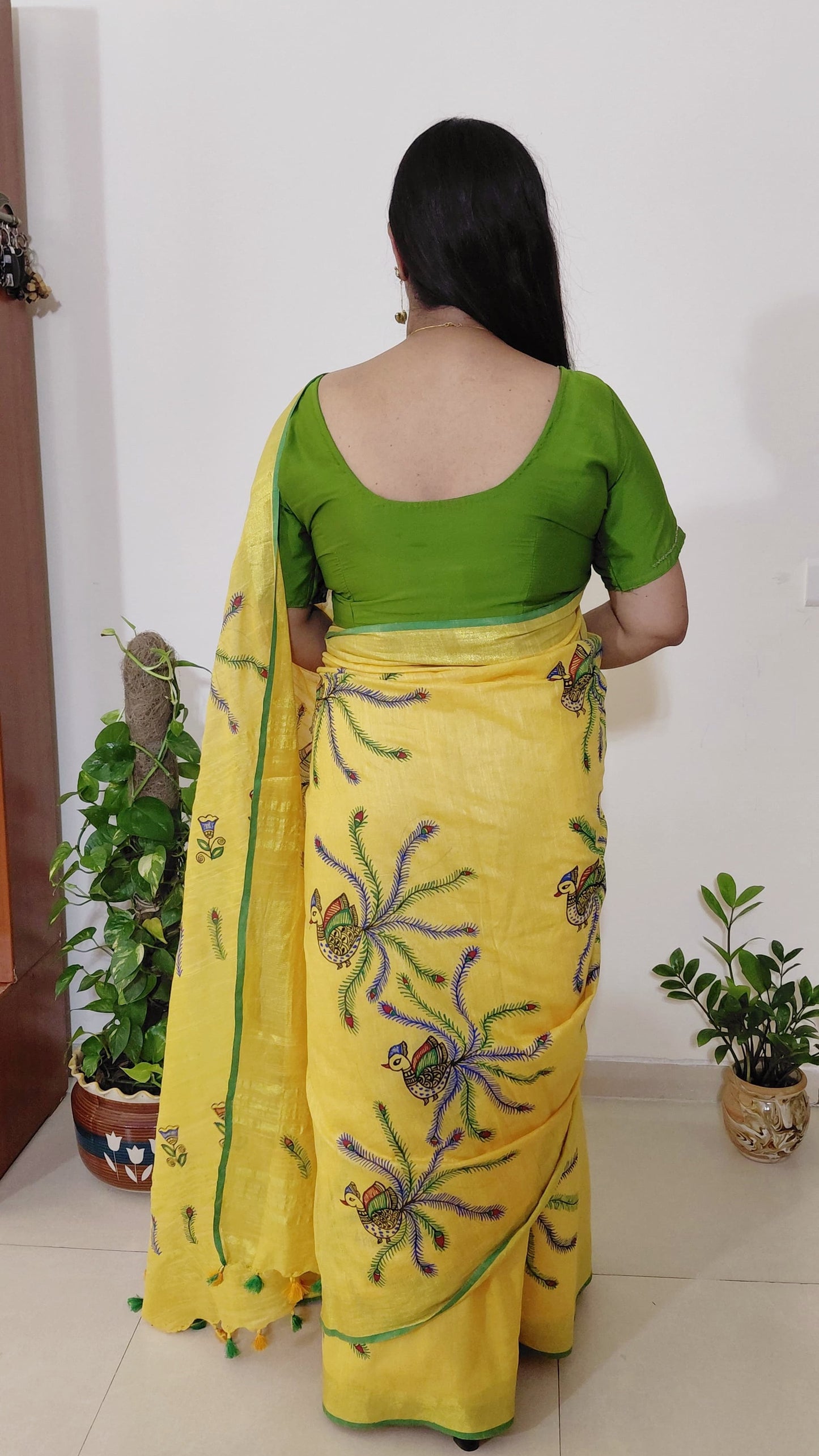 Back view yellow linen saree showing peacock placement across saree