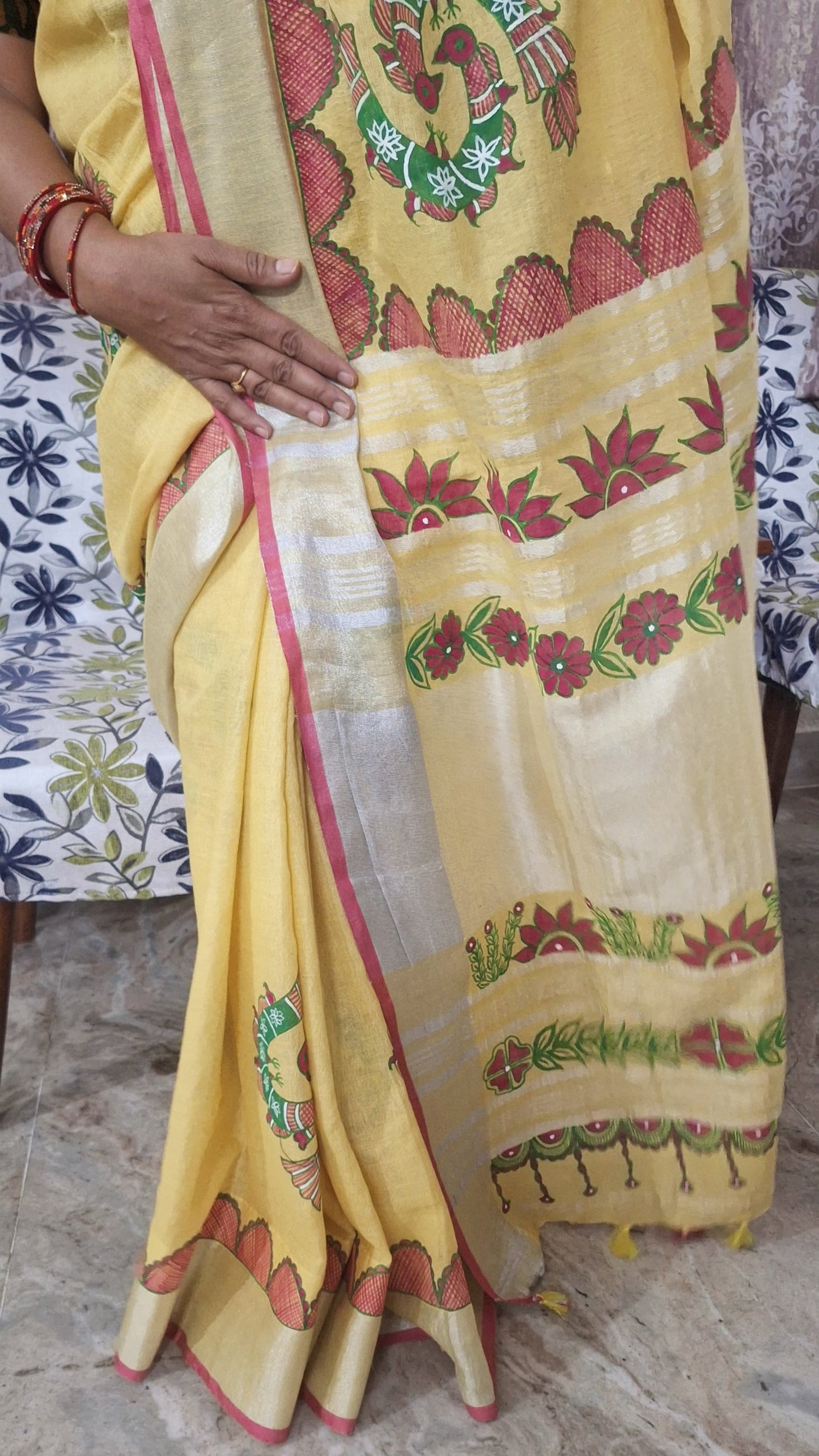 Close-up of hand-painted peacock motif on yellow linen madhubani saree